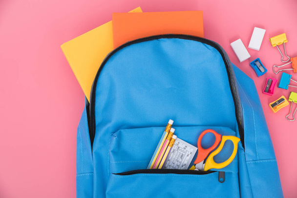 Top view flat lay of blue school bag backpack and accessories tools for children education on pink background, Back to school concept and have copy space for use - Foto, Imagem