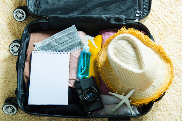 Open suitcase with traveler belongings clothes and accessories of things ready packing to be taken on summer holiday, Travel vacation luggage preparations concept, top view - Photo, Image