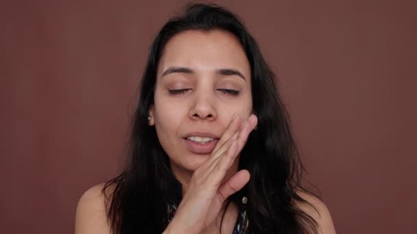 Portrait of indian woman sharing overheard secret in studio - Séquence, vidéo