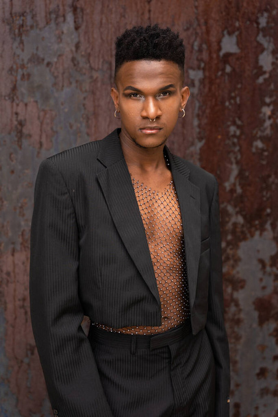 Black ethnic man in a fashionable pose on a metallic background - Valokuva, kuva