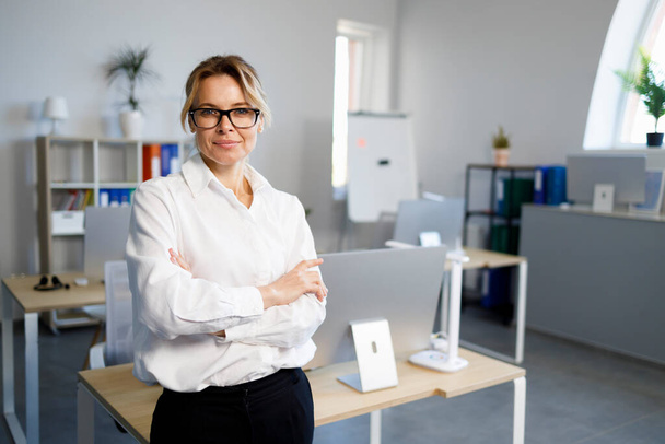 Portrait of confident businesswoman with arm crossed in office - Foto, Imagem