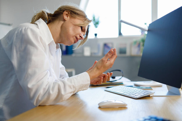 Office woman with carpal tunnel syndrome and wrist pain - Foto, afbeelding