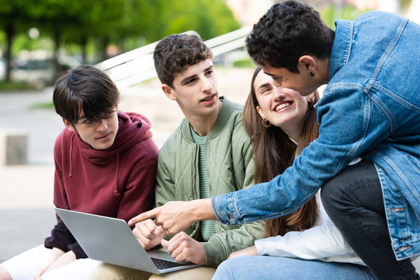 A tinédzserek együtt dolgoznak és tanulnak a laptopon. Csapatmunka az egyetem koncepciójában. - Fotó, kép
