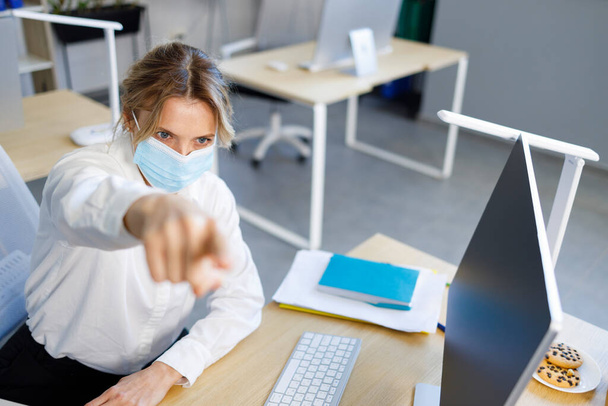 Angry business woman in a medical mask points her finger to the exit - Fotoğraf, Görsel