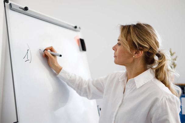 Mujer de negocios o profesora escribiendo en un rotafolio - Foto, Imagen