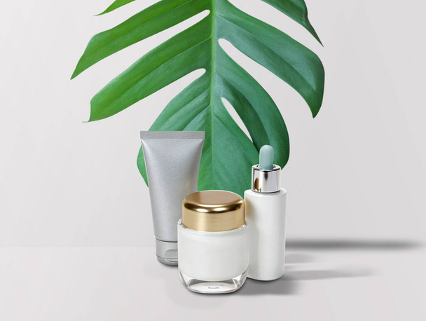 Top view with white cosmetic products and green leaves on orange background. Natural beauty product for design branding mock up concept. - 写真・画像