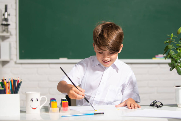 Child boy at school draws with paints. Kids artist creativity. kid learning painting. - Фото, зображення