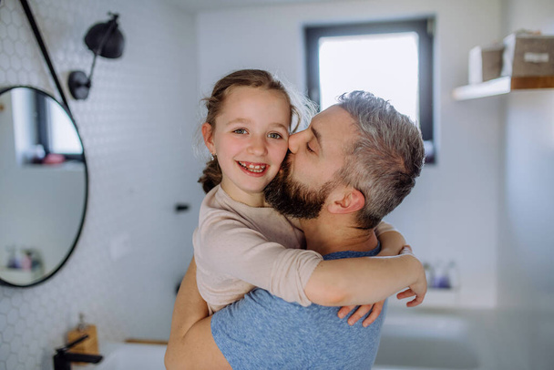 Father kissing his little daughter in bathroom. - Φωτογραφία, εικόνα