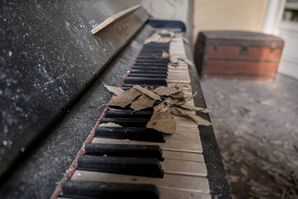 old piano with ruined keys in large abandoned house. High quality photo - Фото, изображение