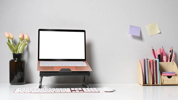 Ноутбук с чистым экраном, цветочный горшок и чашка кофе на белом столе - Фото, изображение