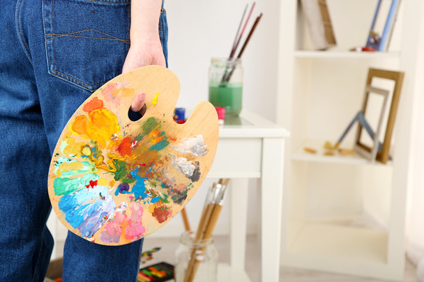 Artist holding palette with paints - Foto, Imagen
