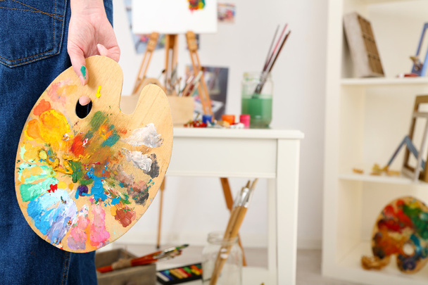 Artist holding palette with paints - Фото, изображение