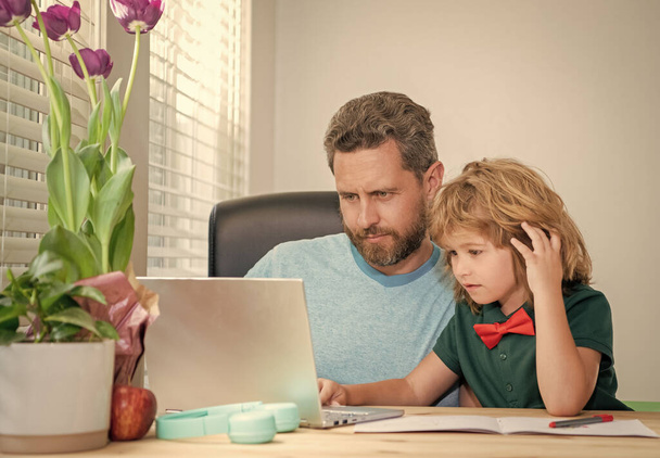 Hausaufgabenbetreuung und Grundschulbildung. zurück zur Schule. Vater und Kind nutzen Computer zu Hause. - Foto, Bild