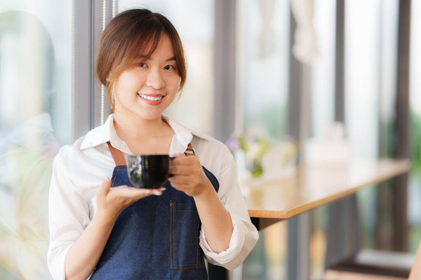 Власник азіатського кафе посміхається, коли кафе відчинене. SME enterneur producer business concept. - Фото, зображення