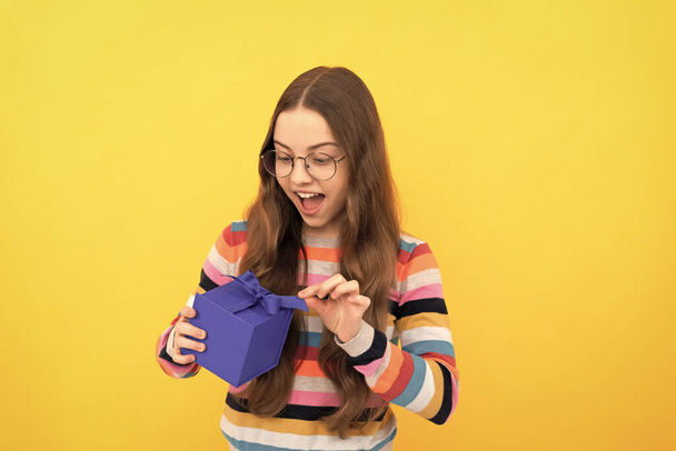 surprised teen girl in eyeglasses open box. boxing day. present and gifts buy - Foto, Imagem