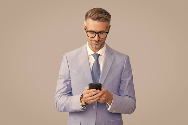 sonriente hombre de negocios guapo en gafas comprobar correo electrónico en el teléfono, blogger - Foto, Imagen