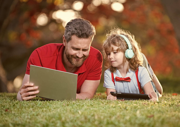 happy family of father and son in park, wireless technology. - Foto, Bild