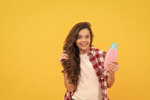 presenting cosmetic product. beauty. kid use shower gel. happy teen girl with shampoo bottle. - Photo, Image