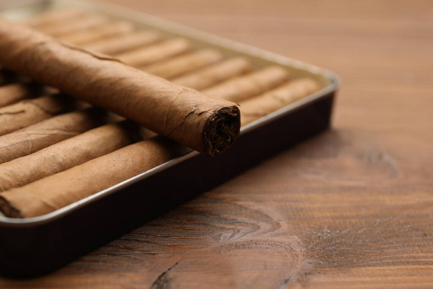 Many cigars in box on wooden table, closeup - Foto, imagen