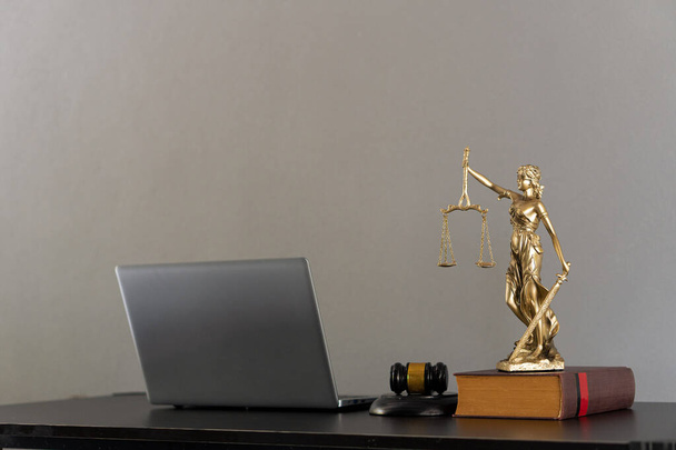La peau de tigre de loi de marteau de la déesse de la justice et de la justice avec l'ordinateur portable sur la table - Photo, image