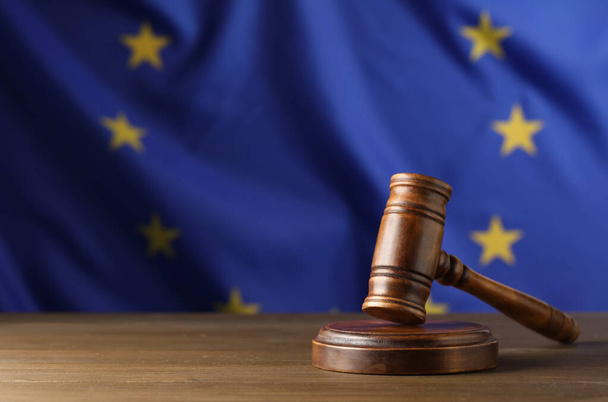 Judge's gavel on wooden table against European Union flag. Space for text - Фото, зображення