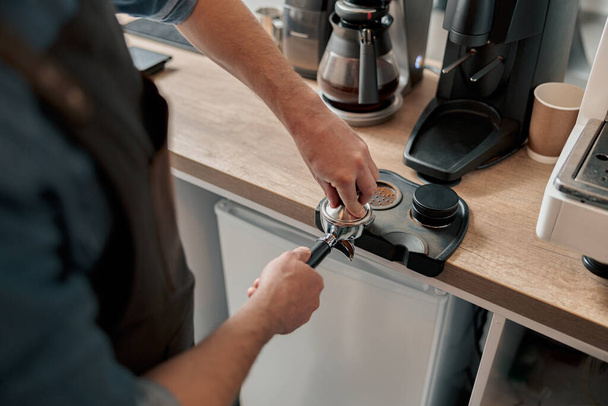 Close up of barista tamping ground coffee for making espresso - Фото, зображення
