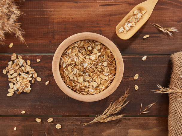 Oat flakes, rolled oats in wooden bowl  - Photo, image