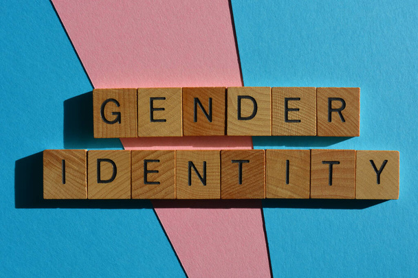 Geschlechtsidentität, Wörter in Buchstaben aus Holz isoliert auf rosa und blauem Hintergrund - Foto, Bild