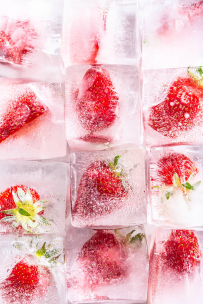Three rows of ice cubes with strawberries - Top of view. - Фото, зображення
