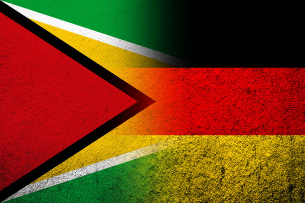 De nationale vlag van Duitsland met de nationale vlag van Guyana. Grunge achtergrond - Foto, afbeelding