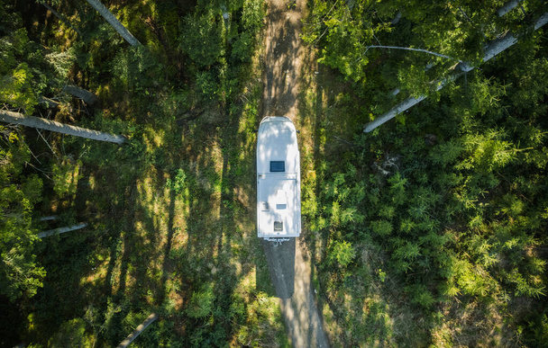 Class C Motorhome Camper Van on a Woodland Country Road Aerial View. Summer Vacation Road Trip.  - Fotografie, Obrázek