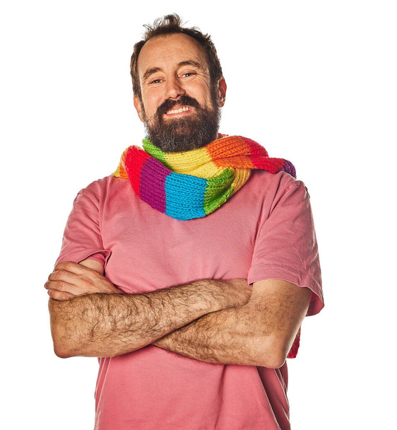 senior man in his 40s, gay in casual clothes with rainbow scarf with lgbt colors. pride day. arms crossed and expression of confidence. - Foto, afbeelding