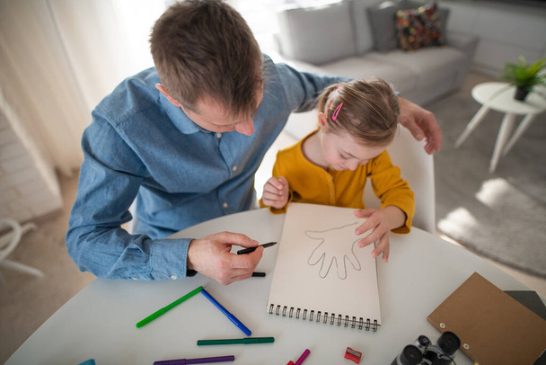 Father with his little daughter with Down syndrome learning at home. - Valokuva, kuva