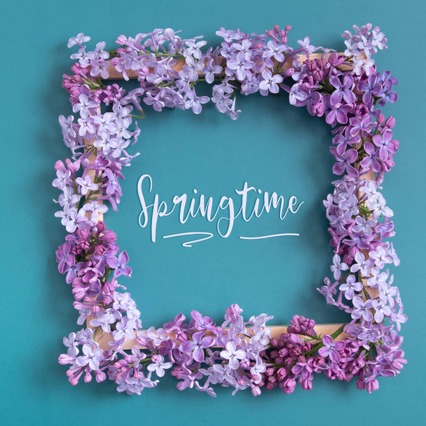 Springtime text and lilac flowers square frame composition on turquoise background.   - Fotó, kép