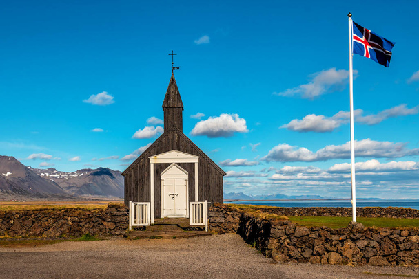 Старий чорний знаменитий церковний Будір та ісландський прапор. Ісландія. Європа - Фото, зображення