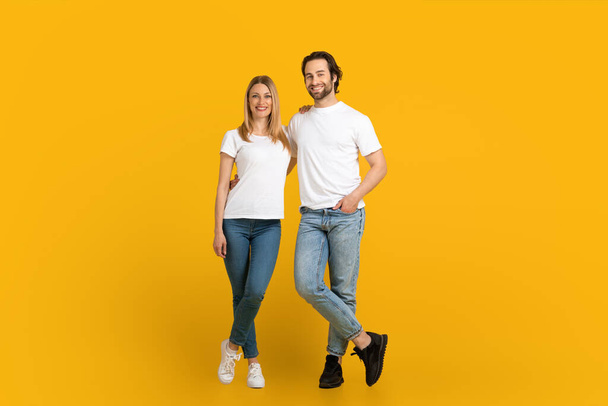 Χαμογελώντας νεαρός Ευρωπαίος με γενειάδα και γυναίκα σταθεί, κοιτάξτε κάμερα, απομονώνονται σε κίτρινο φόντο - Φωτογραφία, εικόνα