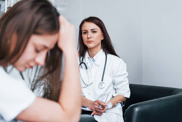Girl have mental breakdown and crying. Young woman have a visit with female doctor in modern clinic. - Foto, Imagem