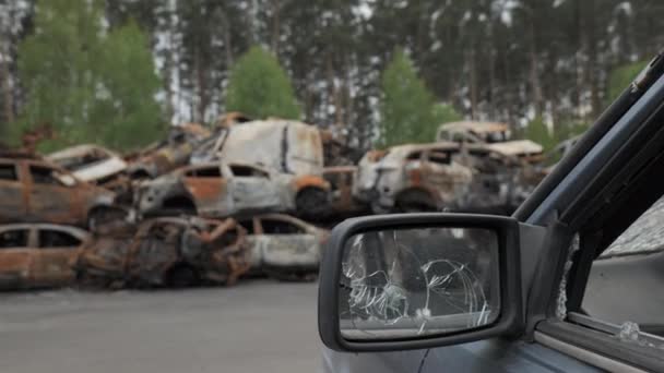 Wielu zastrzelonych i zniszczonych cywilnych samochodów na cmentarzu samochodowym w Irpin, Ukraina - Materiał filmowy, wideo