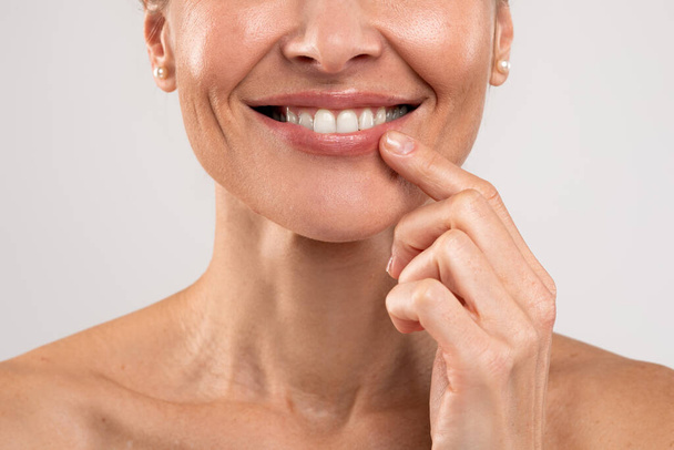 Крупним планом Портрет усміхненої оголена жінка торкається губ пальцем
 - Фото, зображення