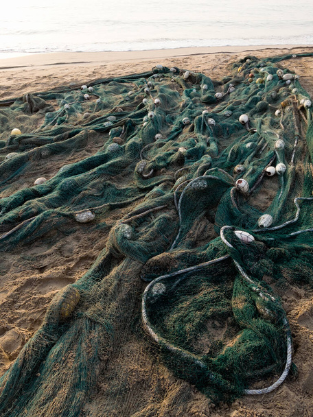 Discarded fishing net on the beach. Marine pollution concept. - Фото, изображение