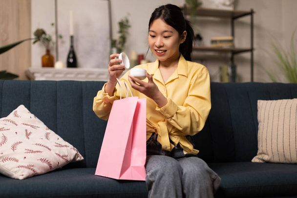 gelukkig aziatische vrouw uitpakken pakket na online winkelen - Foto, afbeelding
