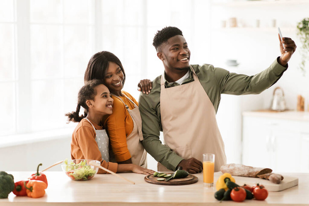 Black Family Making Selfie While Cooking Preparing Dinner In Kitchen - 写真・画像