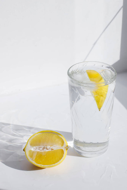 a glass of water with lemon on a light background - Zdjęcie, obraz