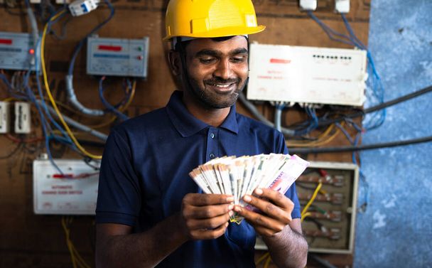 smiling electrician couting money - concept of payment after completion of work, successful career and happiness - Foto, imagen