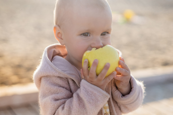 Criança comendo maçã na praia  - Foto, Imagem