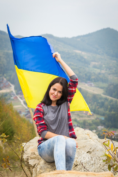 жінка на вершині гори з українським прапором - Фото, зображення