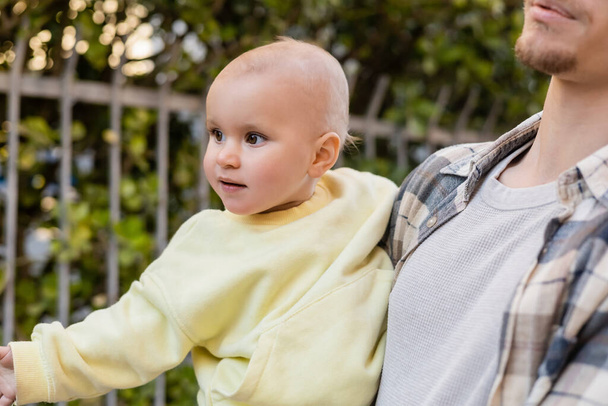 Hombre sosteniendo bebé hija al aire libre  - Foto, Imagen