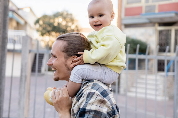 Positiivinen lapsi koskettaa pään vanhemman kaupunkien kadulla Treviso - Valokuva, kuva