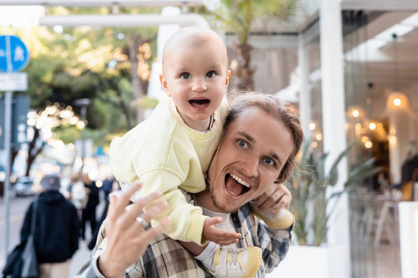 トレヴィーゾの都会の通りを離れて見て興奮した父と子供 - 写真・画像