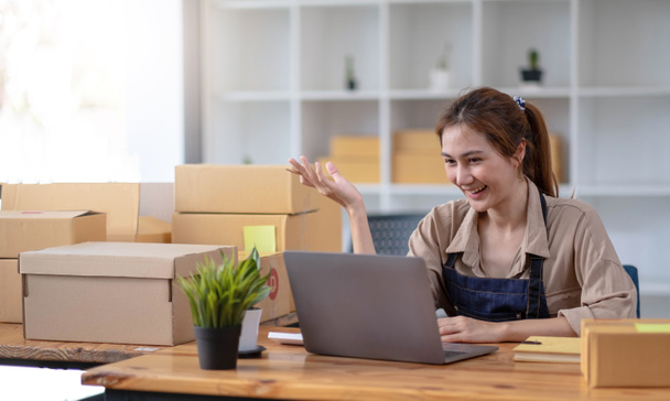 Female entrepreneurs Small Business SME Independent work at home, using laptops for commercial checking, online marketing, packing boxes, SME sellers concept, online sales - 写真・画像